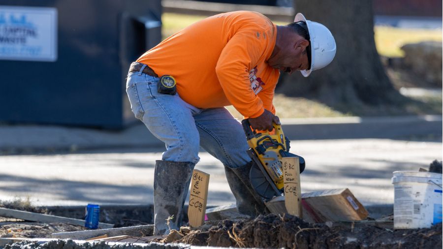 Crew member cutting with saw